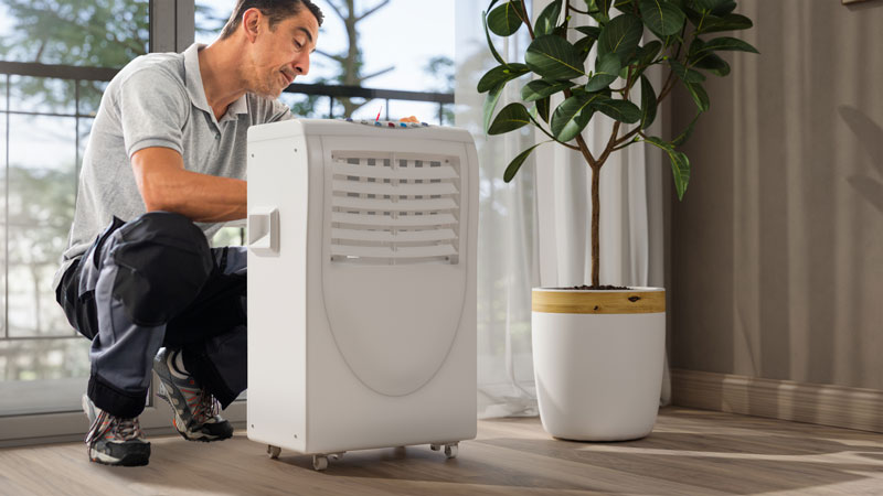 Un réparateur inspecte le climatiseur mobile